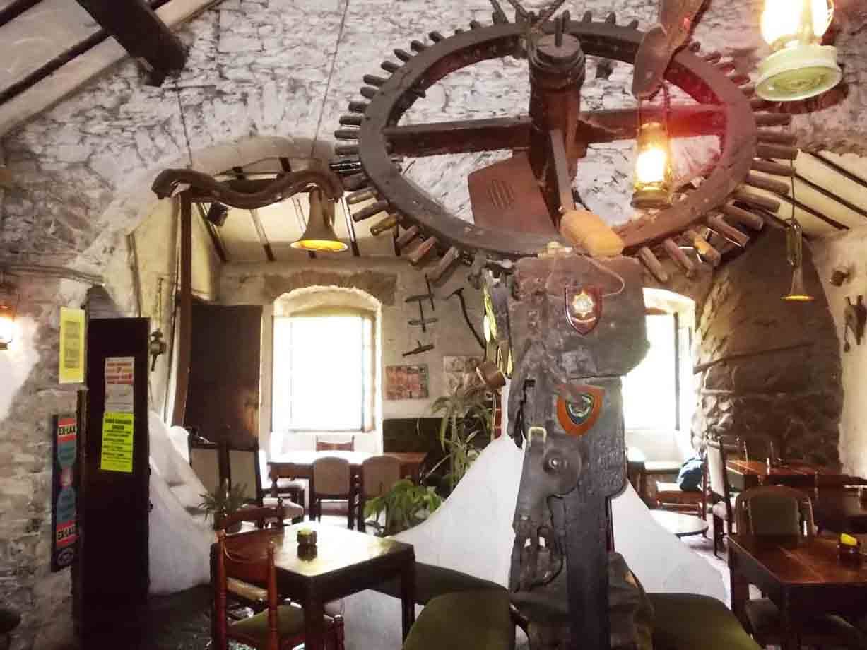 Ingranaio di legno antico in un vecchio mulino oggi trattoria con tavoli in legno