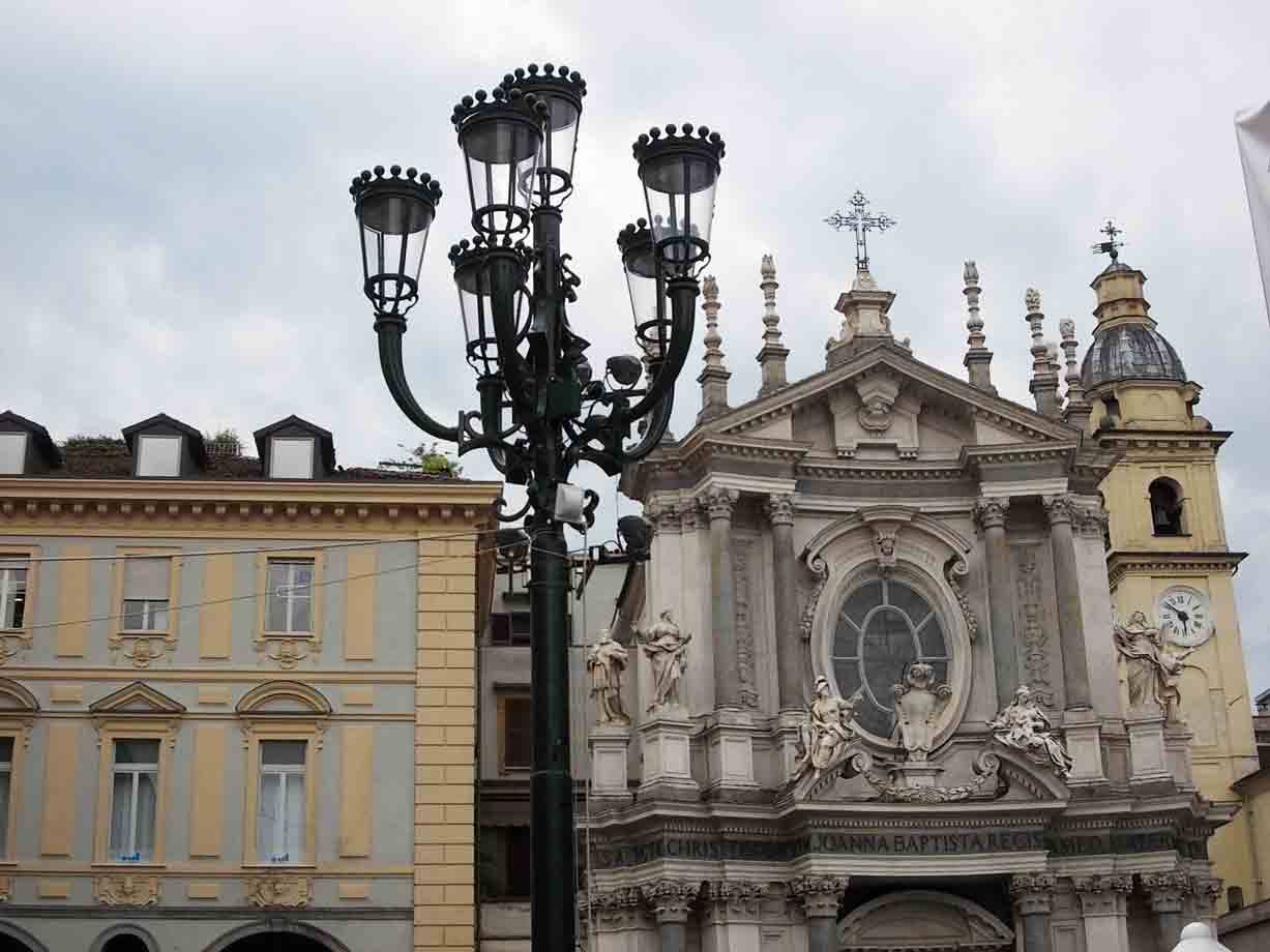 Lampioncino in ghisa verde davanti a una chiesa barocca con statue
