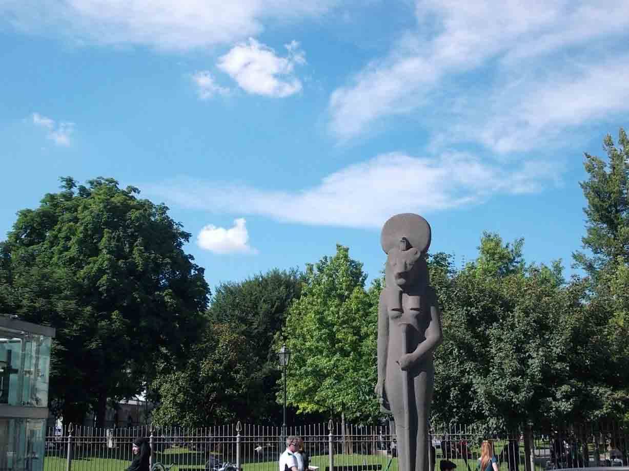 Statua in pietra della dea leonessa Sekhmet in un parco alberato