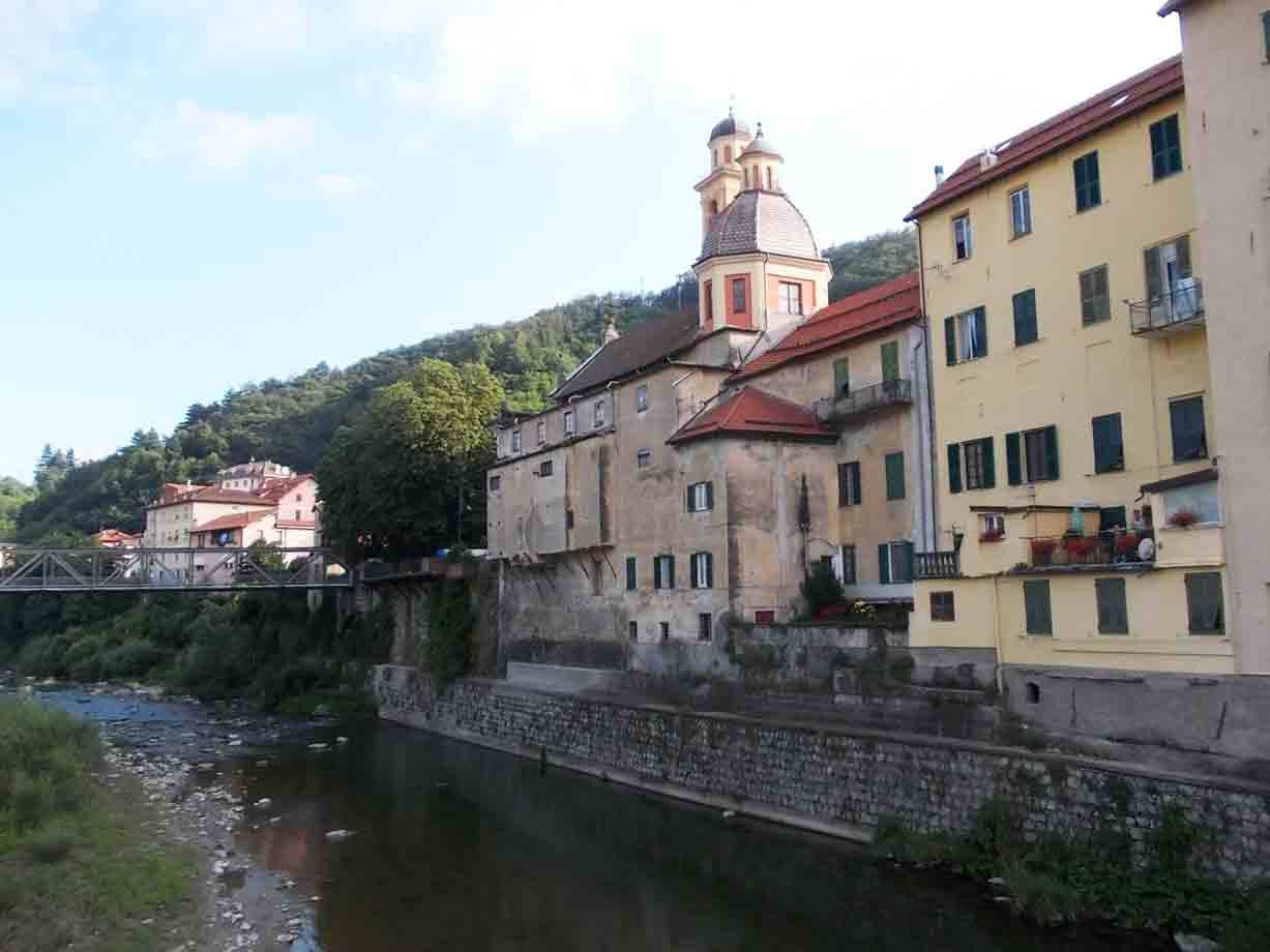 Fiume con case colorate e chiesa con cupola, ponte metallico a sinistra