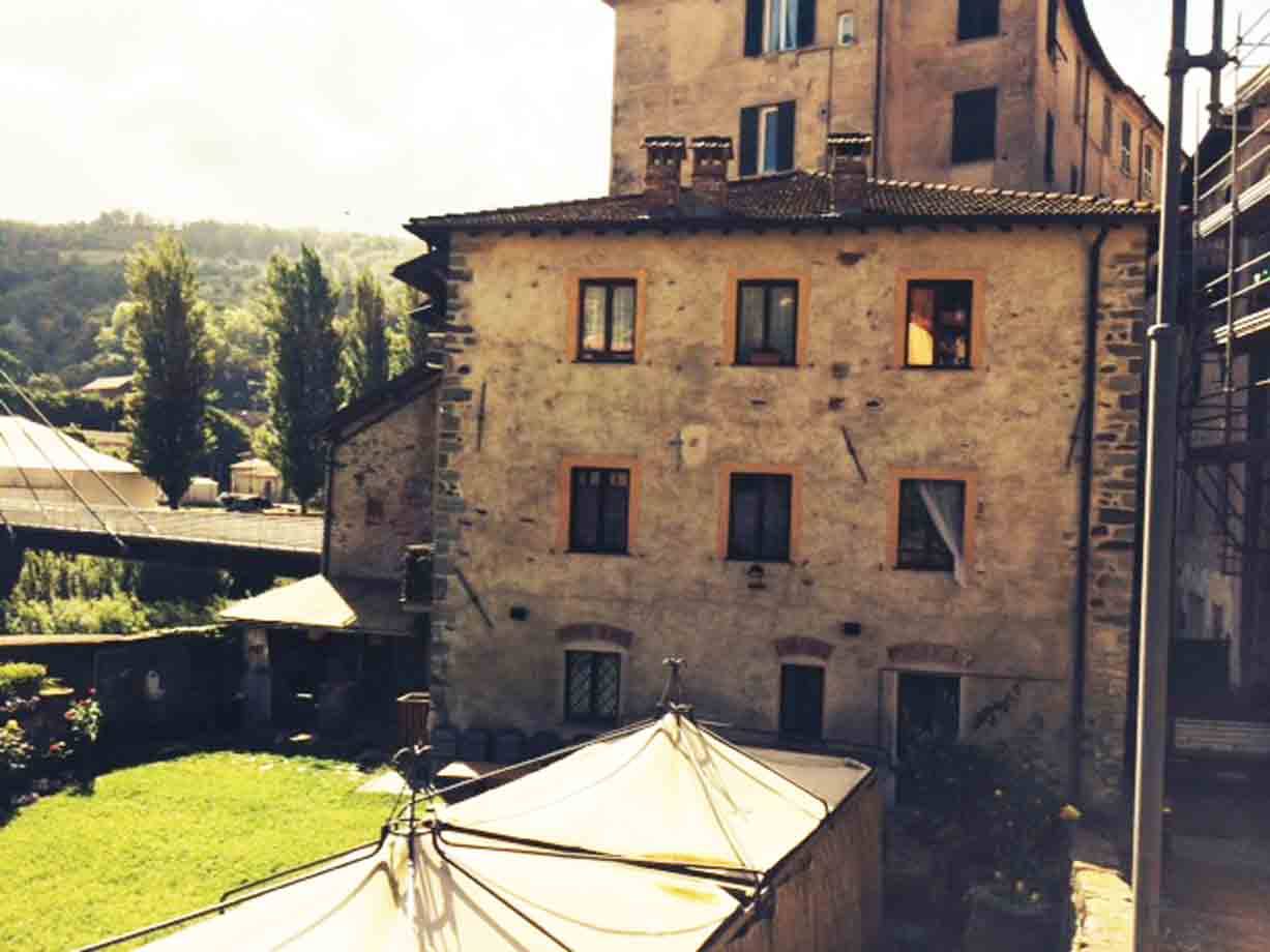 Antica casa in pietra con tendoni bianchi e giardino verde
