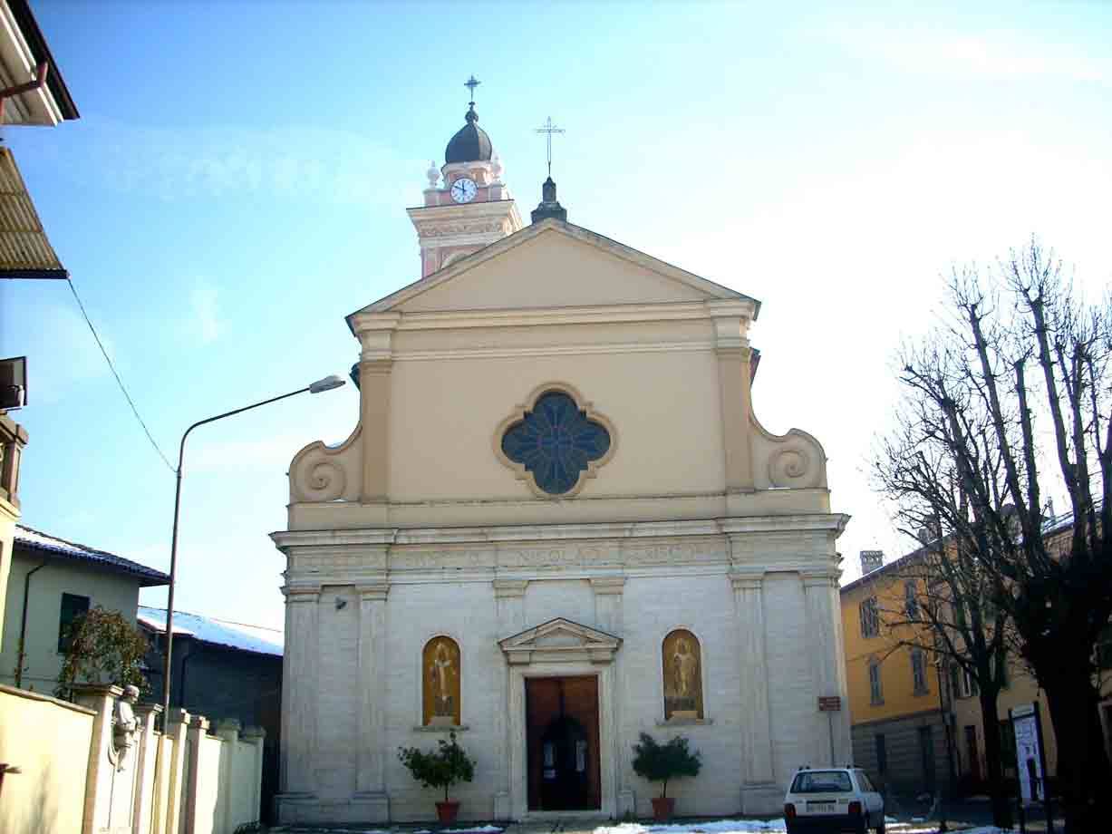 Chiesa con facciata chiara, rosone quadrilobato e campanile, cielo azzurro