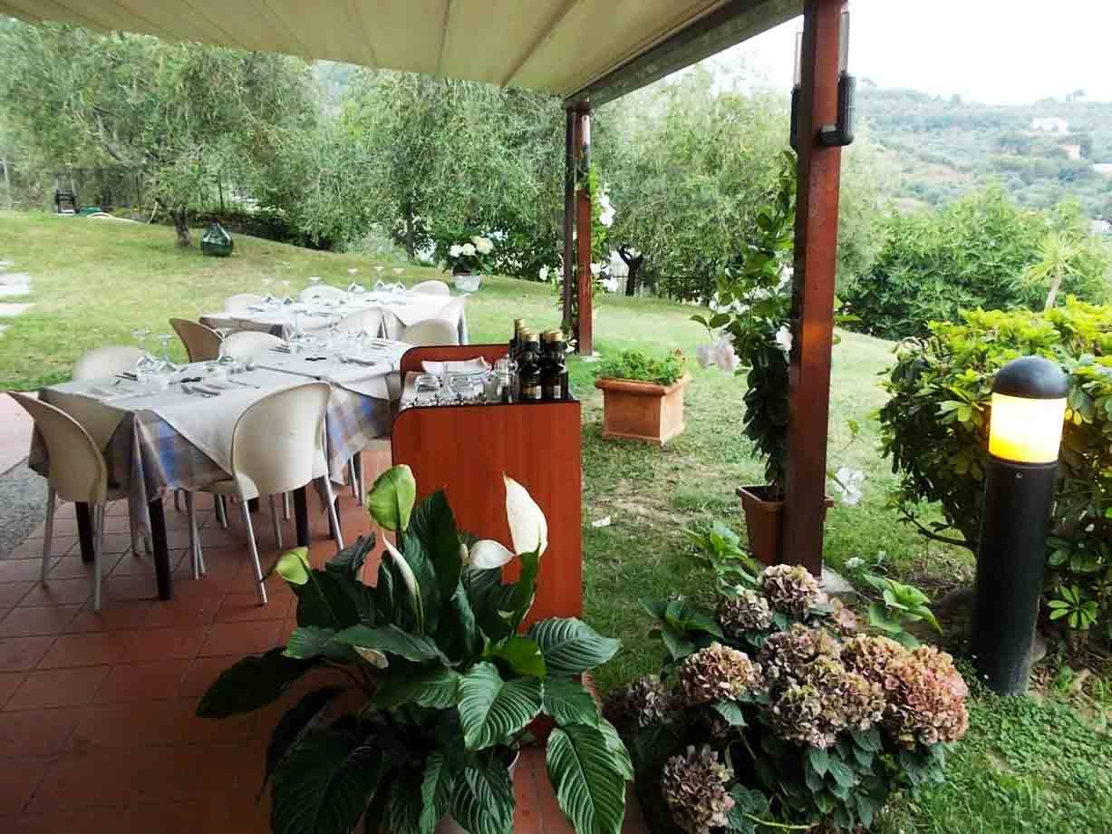 Tavoli apparecchiati sotto il gazebO in legno, ortensie e calle nel giardino