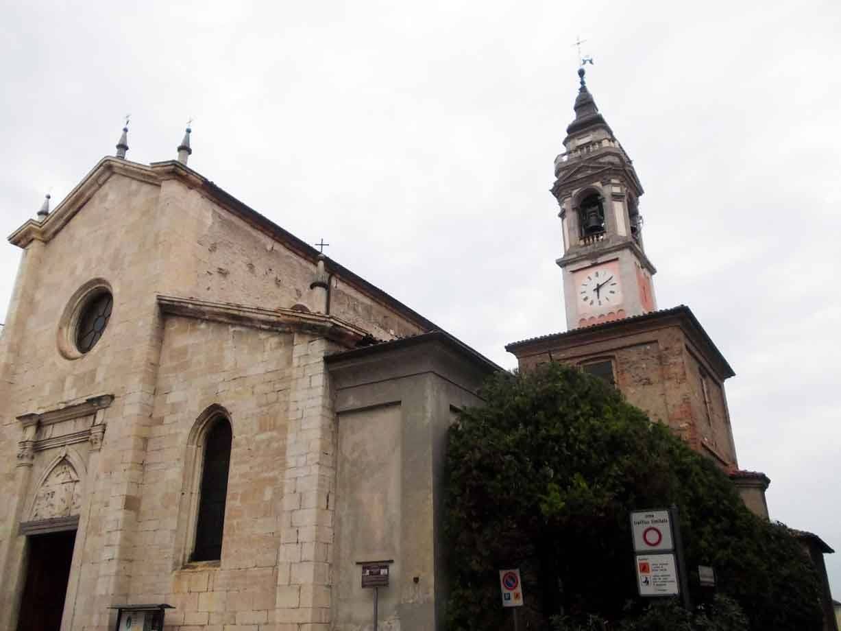 Chiesa in pietra con campanile dell'orologio sotto cielo grigio
