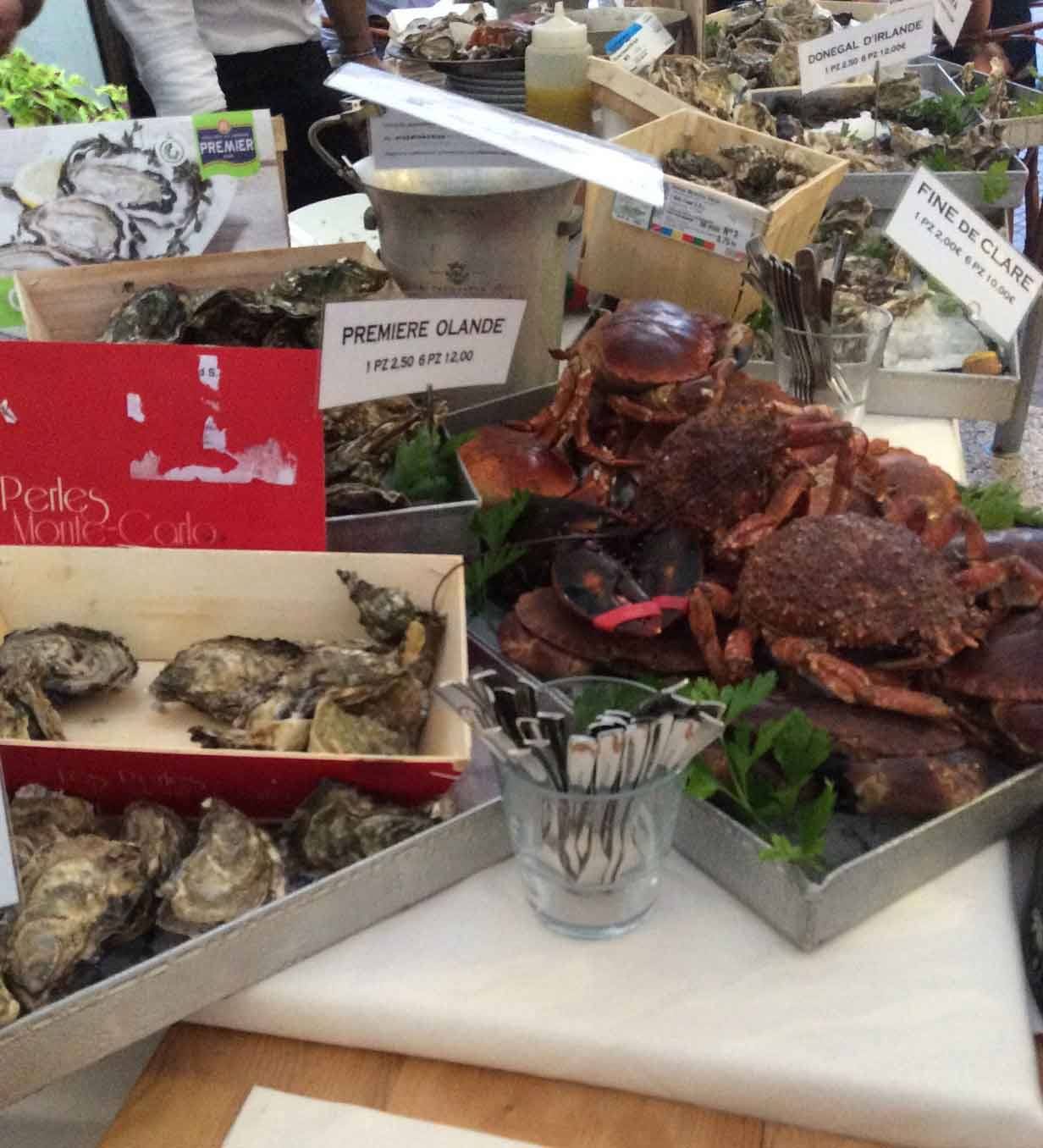 Granchi e ostriche fresche in ceste di legno al banco del mercato del pesce