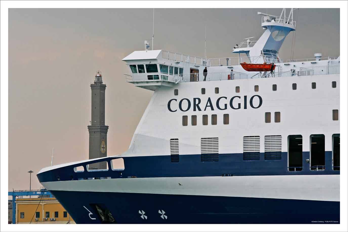 Traghetto Coraggio attraccato nel porto, dietro la Lanterna di Genova