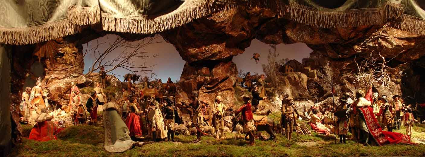 Presepe napoletano con statuine tra rocce e figure in costume