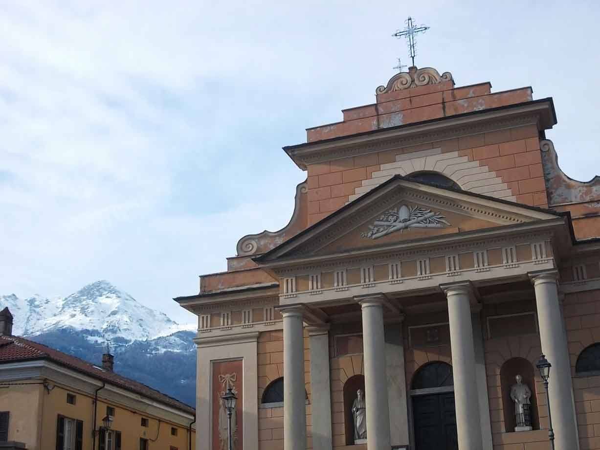 Chiesa con colonne e croce davanti alle montagne innevate