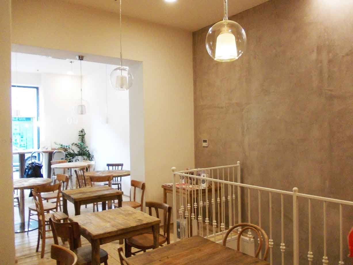 Interno di caffè con tavoli in legno, sedie curvate e lampade a sospensione in vetro