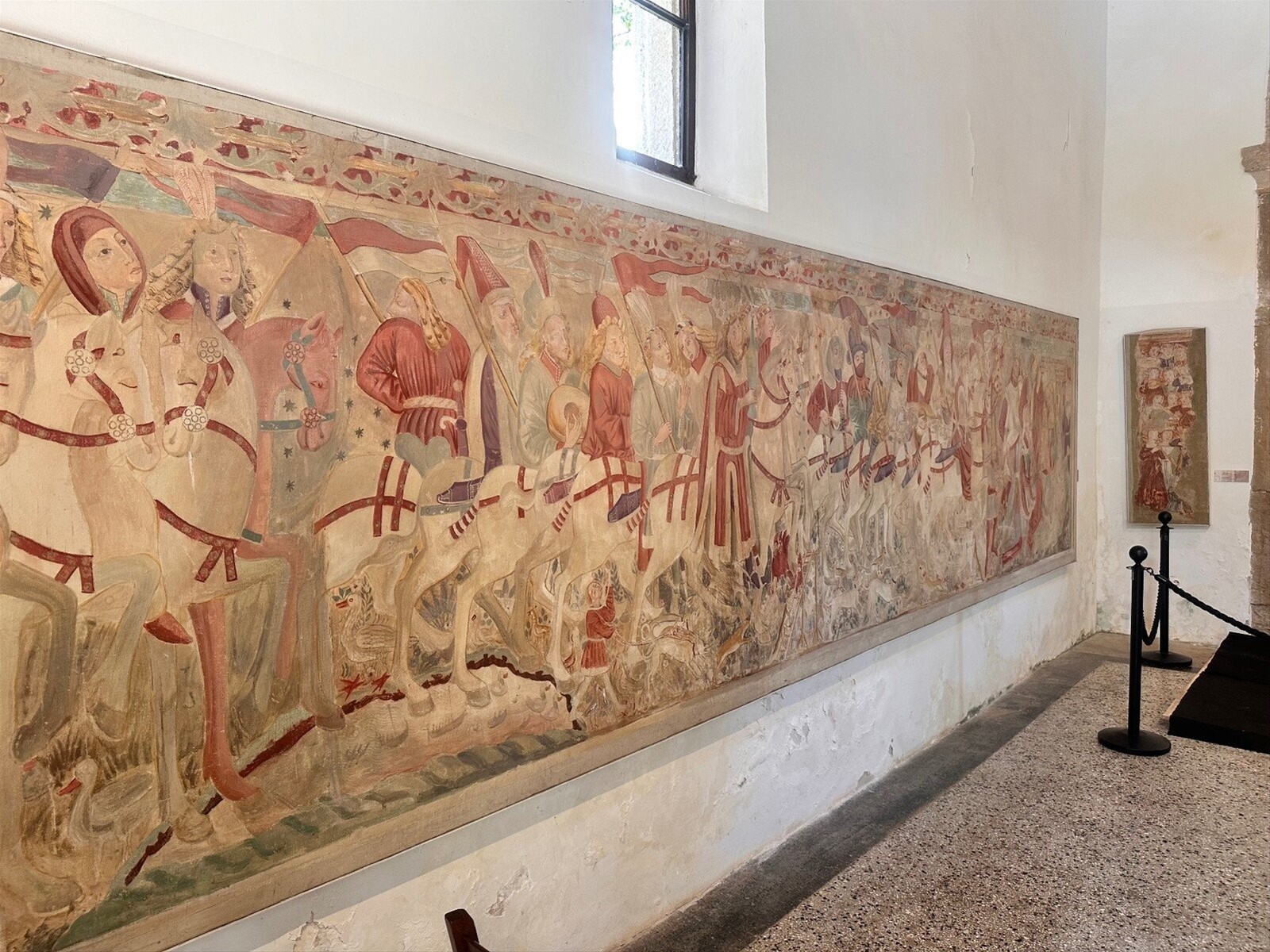Lungo il grande affresco dei cavalieri, tempo sospeso tra i secoli.