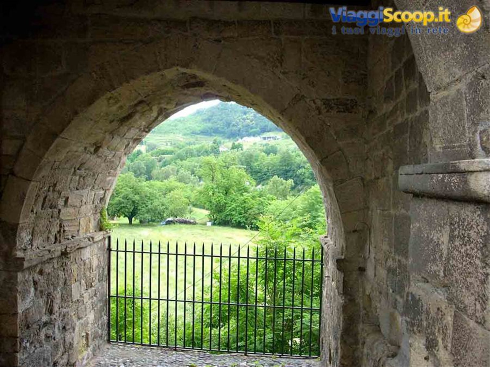 Il verde della campagna attraverso l'arco del Portino